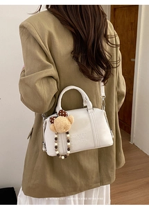 Detail of white Boston bag with teddy bear charm and ZSKERT AIR PARIS embossed lettering