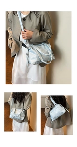 Detail view of light blue vintage tote bag with dual handles and detachable silver strap