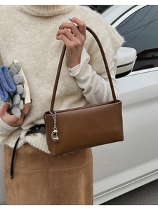 Dark brown matte leather baguette shoulder bag with stylish silver streamline pendant