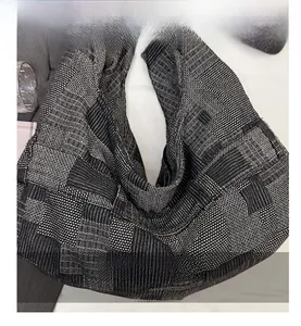 Detail view of the black and grey checkered tweed texture on the crescent tote bag