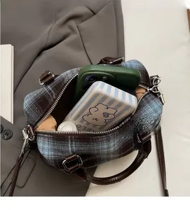 Top view of plaid handbag interior showing storage capacity for phone and accessories