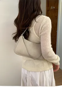 Détail du sac hobo minimaliste en cuir ivoire avec chaîne argentée et forme en croissant