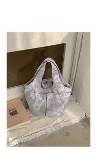Detail view of large floral embroidered tote bag with convenient side pockets and sturdy handles