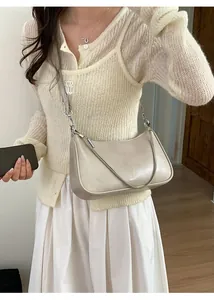 Détail du sac hobo beige avec chaîne argentée et logo NOFILTER sur le devant