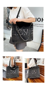 Detail of vintage washed black denim tote bag featuring frayed LOVE letter embroidery