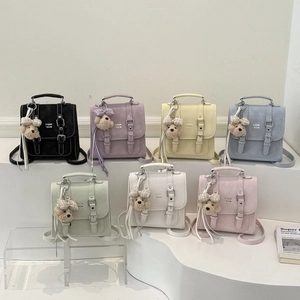 Multiple macaron-colored mini backpacks with flap buckle straps and plush dog charms