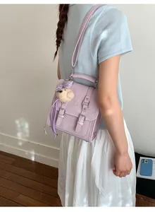 Detail of lavender synthetic leather backpack with cute teddy bear charm and straps