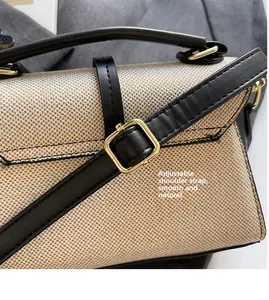 Détail de la bandoulière réglable en cuir avec boucle en métal doré sur un sac tissé