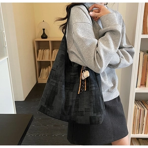 Detail of dark grey geometric patterned shoulder bag with coffee cup charm pendant