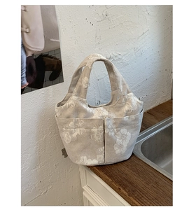 Detail of floral embroidered canvas tote bag with functional outer storage pockets