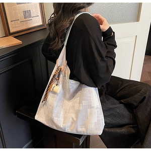 Detail of canvas tote bag featuring abstract grey patterns and a coffee cup charm