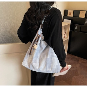 Detail of blue and grey canvas tote bag with coffee charm and leopard ribbon accessory