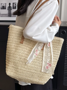 Grande borsa a secchiello in paglia intrecciata color crema con cinturini in pelle marrone