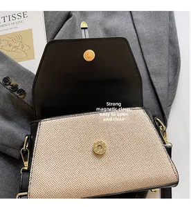 Vue détaillée de la boucle magnétique dorée sur un sac à main tissé beige chic