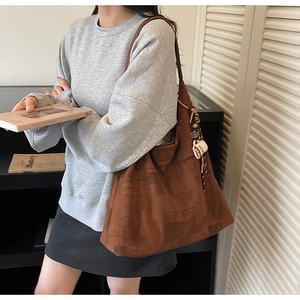 Detailed close-up of dark brown textured tote bag with wood bead and coffee cup charm