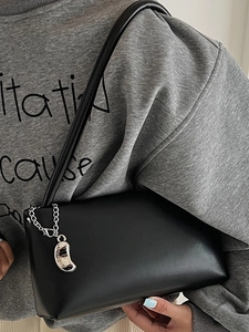 Minimalist black baguette shoulder bag with silver chain and half-moon charm detail