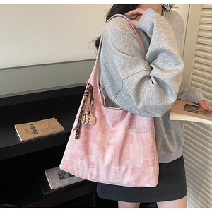 Detailed view of pink checkered tote bag with coffee cup charm and woven strap