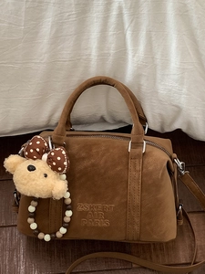 Brown suede Boston handbag with cute bear charm and elegant pearl style strap details