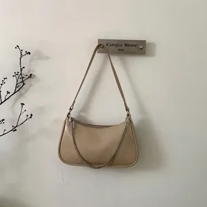 Sac hobo minimaliste en cuir beige avec une élégante chaîne en métal argenté