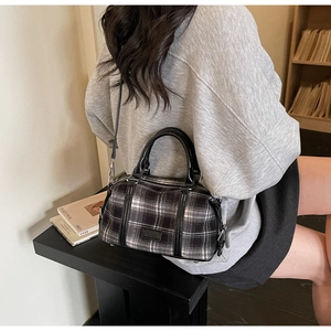 Detail of a vintage plaid Boston bag with black leather trim and detachable shoulder strap