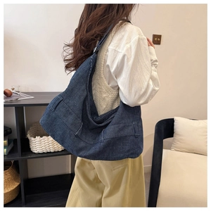 Detail of navy blue corduroy hobo bag showing ribbed texture and wide shoulder strap