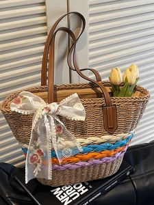 Handwoven straw tote bag with colorful stripes and lace flower bow for summer beach vacations