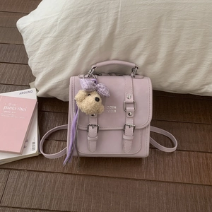Detail of lavender mini backpack with metal buckle straps and a cute teddy bear charm