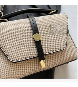 Détail de la texture en tissu tissé avec bordure en cuir noir et boucle dorée du sac