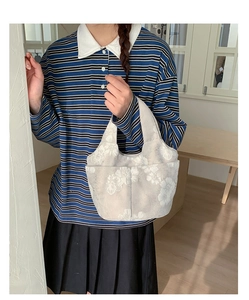 Detailed view of the large capacity canvas tote with white floral embroidery patterns