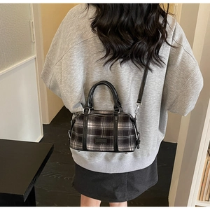Classic black and white checkered Boston bag shown from behind on a model shoulder