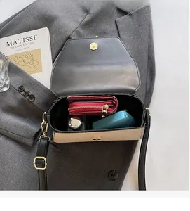 Vue intérieure du sac bandoulière bicolore montrant l'espace pour le portefeuille et objets