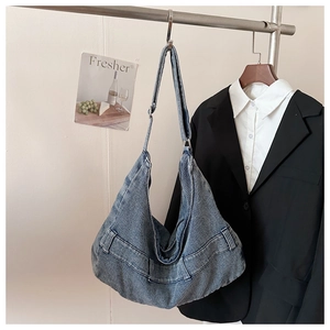 Detail of blue denim tote bag with vertical stripes texture and adjustable shoulder strap