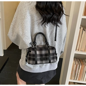 Detail of vintage black and white checkered mini Boston bag with glossy black handles