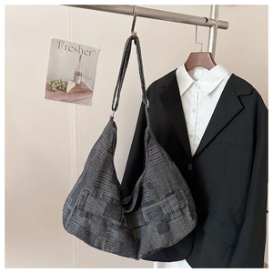 Detail of grey and black patchwork woven tote bag hanging with stylish office outfits