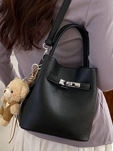 Black lychee leather bucket bag with silver twist lock and cute bear charm accessory