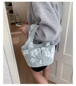 Detailed view of the embroidered bucket bag showing multi-pocket design and floral pattern
