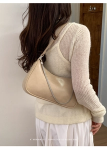 Vue détaillée du sac beige avec chaîne en métal et bandoulière en cuir sur modèle