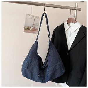 Detail of navy blue corduroy hobo bag showing ribbed texture and adjustable strap hanging
