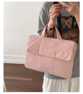 Detail of light pink quilted laptop bag with square stitching and front pocket flap
