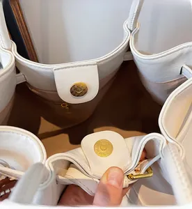 Détail du cabas en cuir blanc avec fermeture magnétique dorée et doublure intérieure