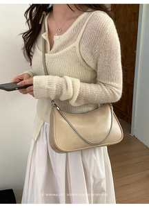 Détail du sac hobo en cuir crème avec lettrage NO FILTER et bandoulière chaîne