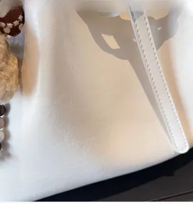 Gros plan détaillé du sac cabas blanc en cuir à grain litchi avec une texture souple