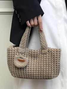 Minimalist beige woven hobo bag with waffle texture and handmade leather tag detail