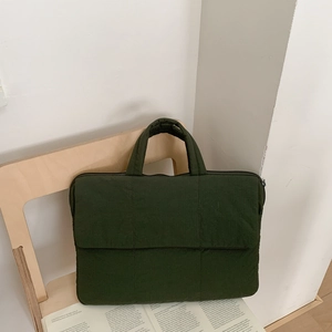 Detailed view of olive green quilted laptop bag with durable padded fabric and zipper