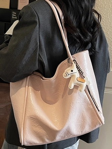 Pink oversized tote bag with wrinkled texture and zebra print pony charm in use