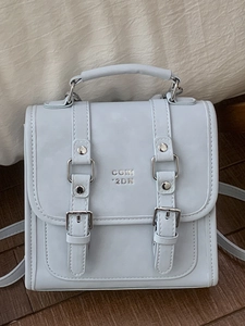 Modern light blue rectangular handbag with silver buckles and elegant crossbody strap