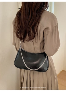Détail d'un sac porté épaule demi-lune noir avec chaîne argentée sur un mannequin