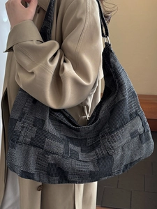 Large woven hobo shoulder bag in black and grey, showcased on model with casual style