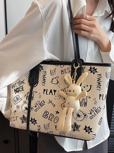 Minimalist white tote bag with black graffiti print and plush bunny keychain accessory