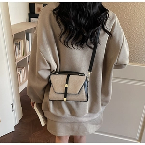 Détail d'un sac bandoulière patchwork en toile beige avec bordures en cuir noir